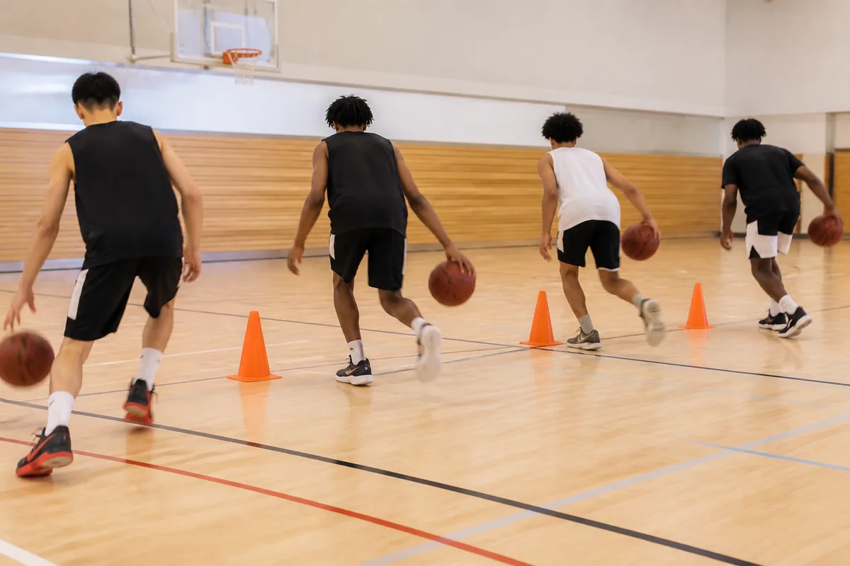Jeunes joueurs alignés sur un parquet lors d un atelier de dribble avec plots