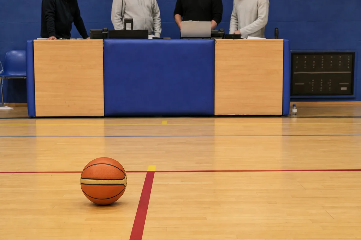Table de marque installée en bord de terrain dans un gymnase de basket